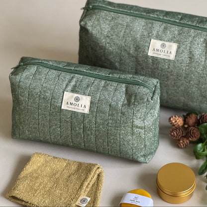 Two green textured bags with 'Amolia' branding and small containers on a light background.
